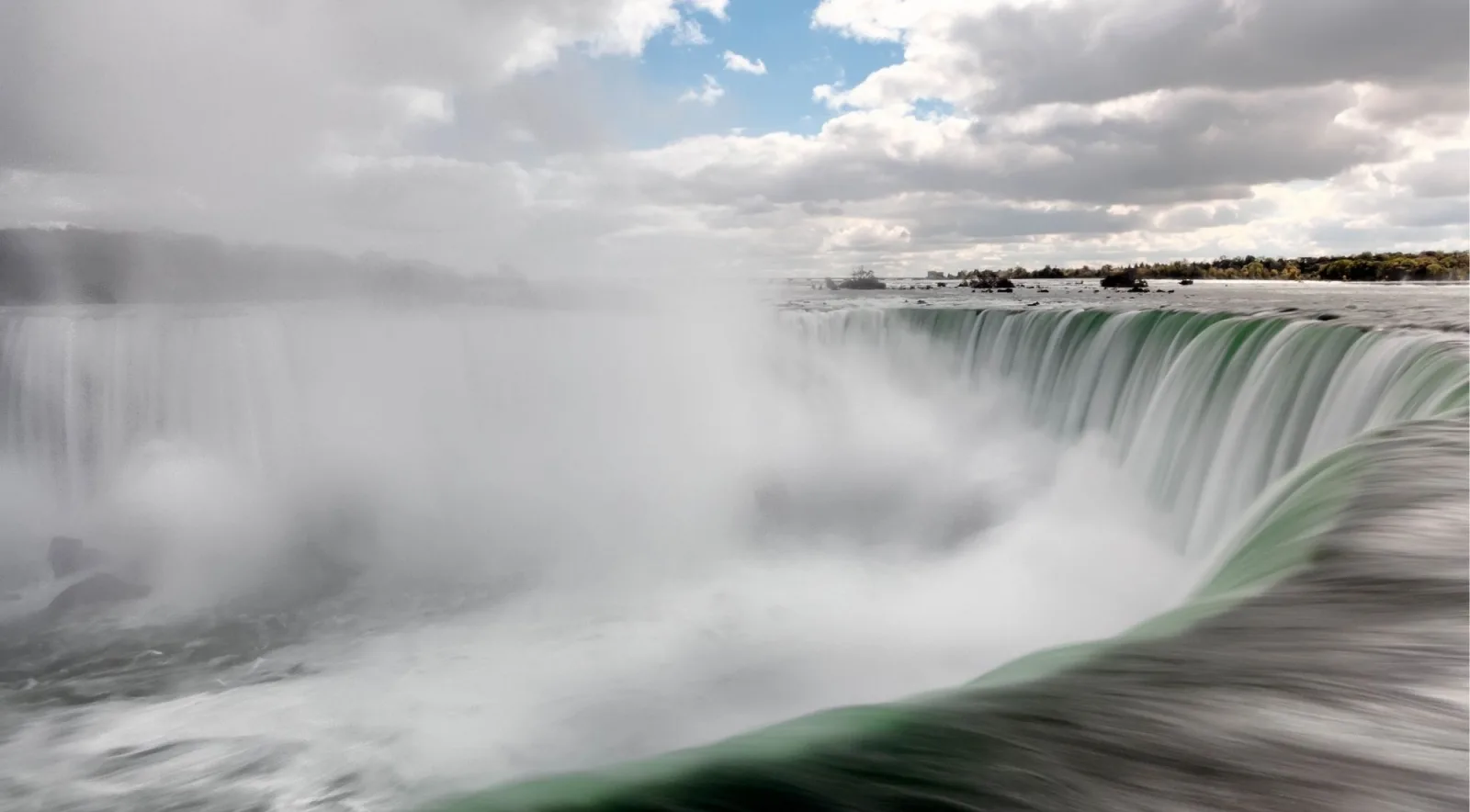 Long exposure of the brink of Horseshoe Falls, the green crest smoothed into silk beneath rising mist