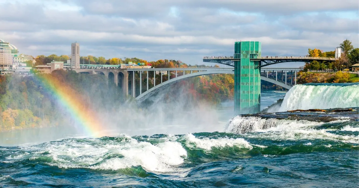 The Rainbow Bridge between Canada and the USA, with a rainbow over the Niagara River and the American Falls observation tower on the right